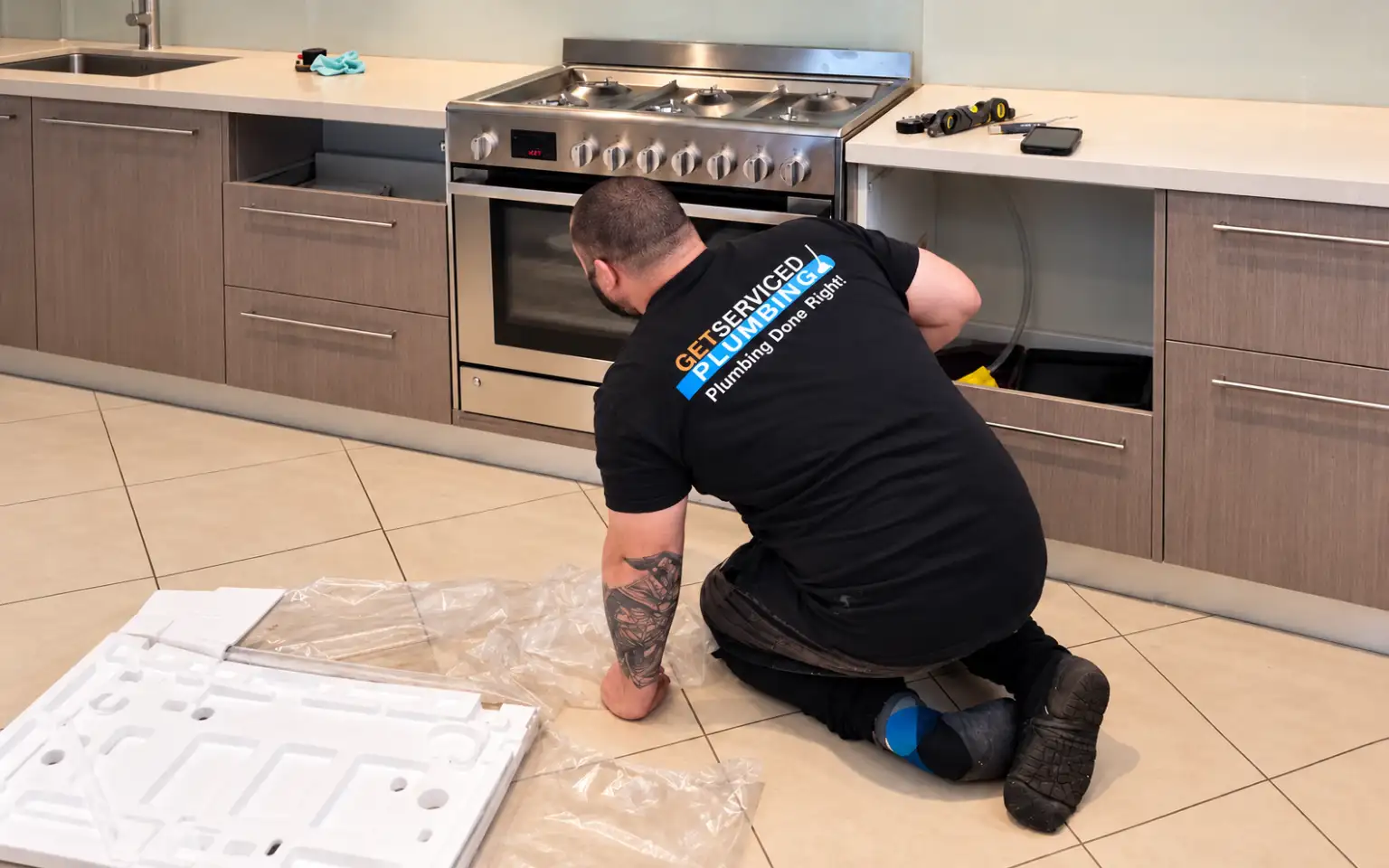 Gas fitting 1 Dennis working on an oven in a kitchen